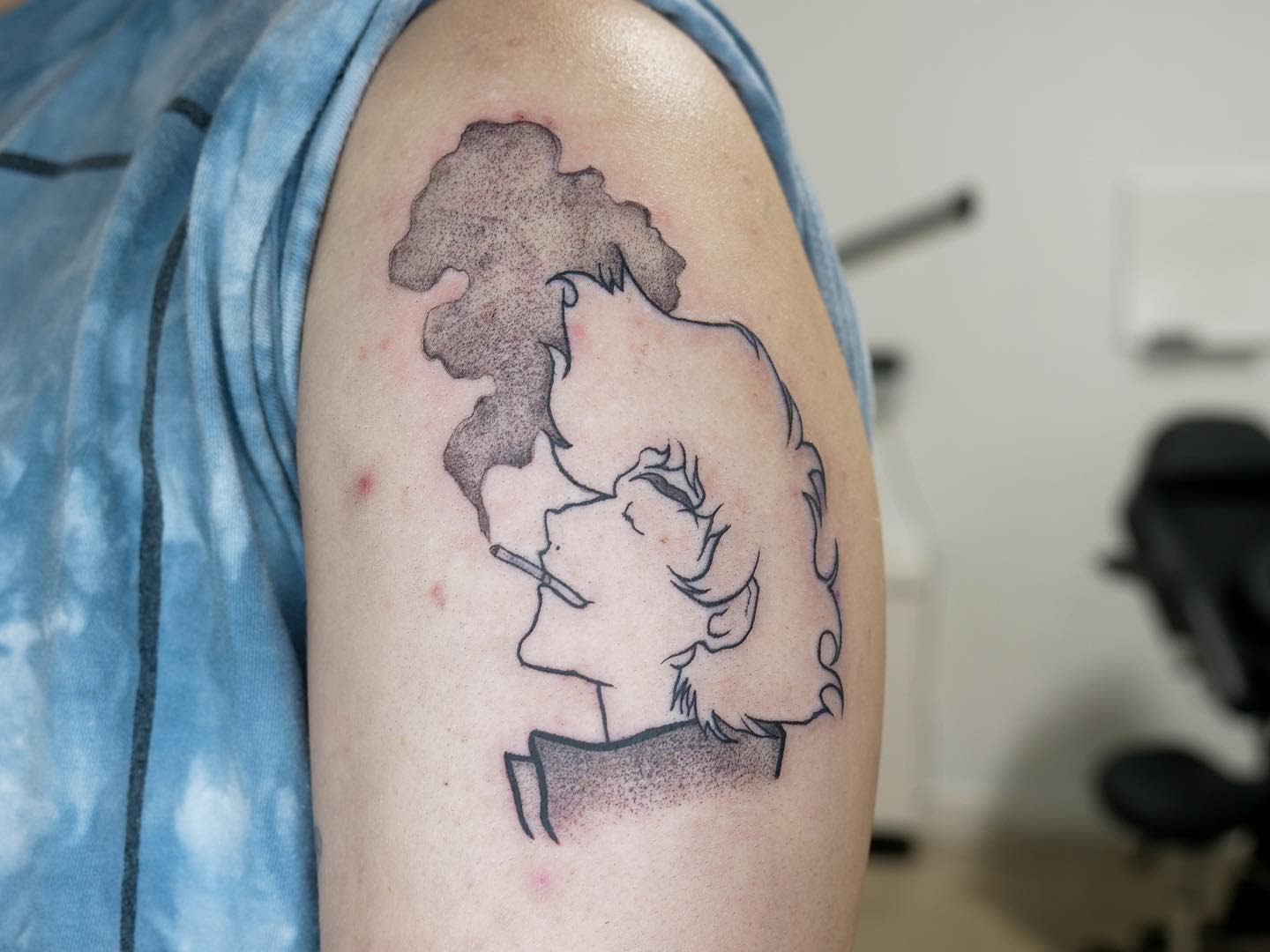 Minimalist tattoo of Spike Spiegel from Cowboy Bebop, smoking a cigarette with smoke billowing upwards